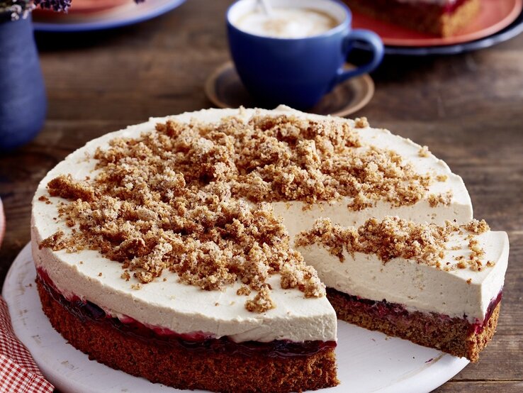 Auf einem Teller liegt eine angeschnittene Capucino-Krümeltorte. Sie ist cremig und fluffig.