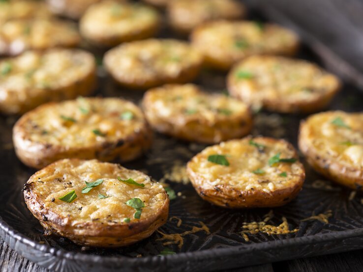 Parmesan-Kartoffeln auf einem Backblech, mit Käse überbacken.