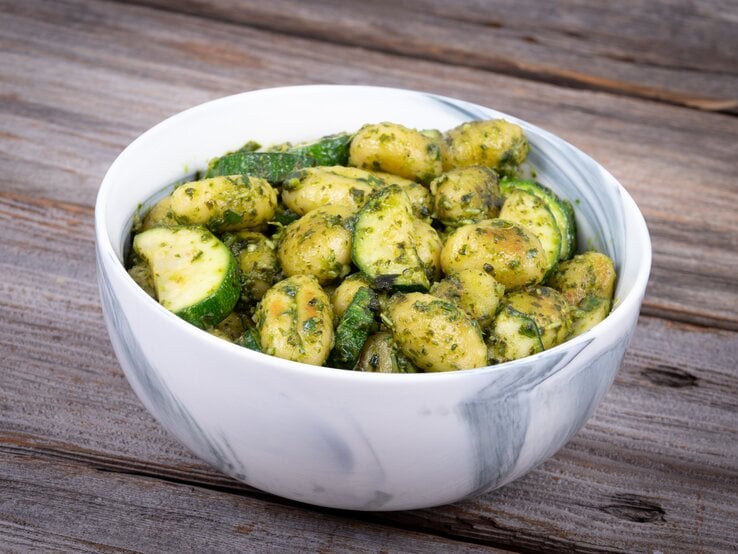 Eine Schale Gnocchi-Zucchini-Salat steht auf einem Tisch