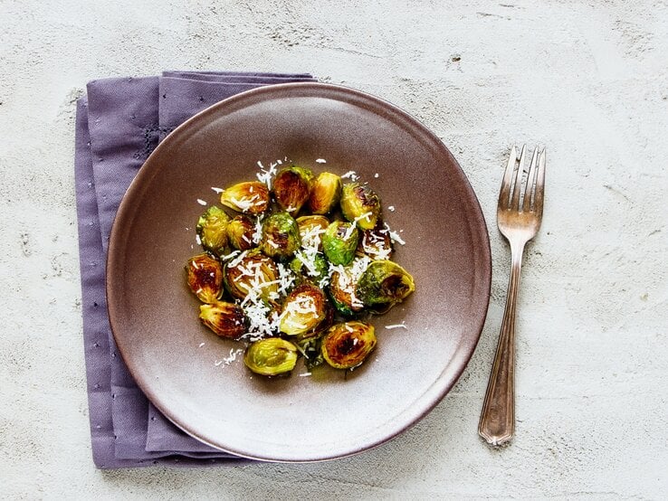 Rosenkohl mit Parmesan und Knoblauch auf einem Teller. 