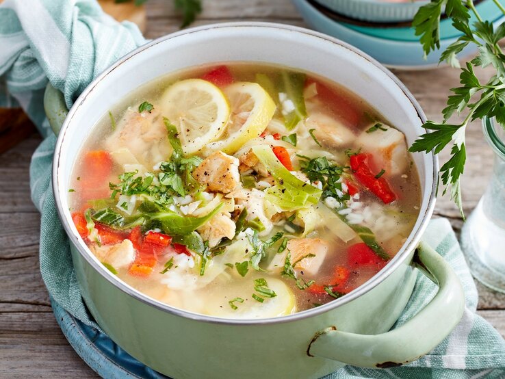 In einer Schüssel ist eine Portion Zitronen-Hähnchen-Eintopf angerichtet. Sie ist mit Zitrone, Paprika und Spitzkohl zubereitet. 