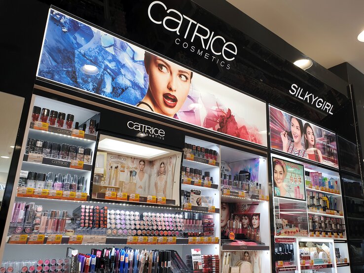 Kosmetikladen-Display, das eine Vielzahl von Produkten der Marken Catrice Cosmetics und SilkyGirl präsentiert. Die Produkte sind übersichtlich auf mehreren Regalen angeordnet.