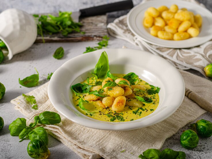 Gnocchi in Rosenkohl-Curry auf weißem Teller. 