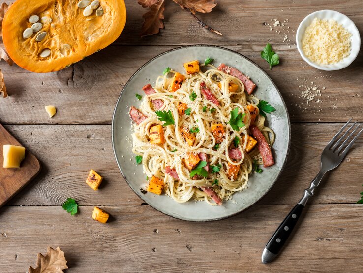 Kürbis-Carbonara auf Holztisch. 