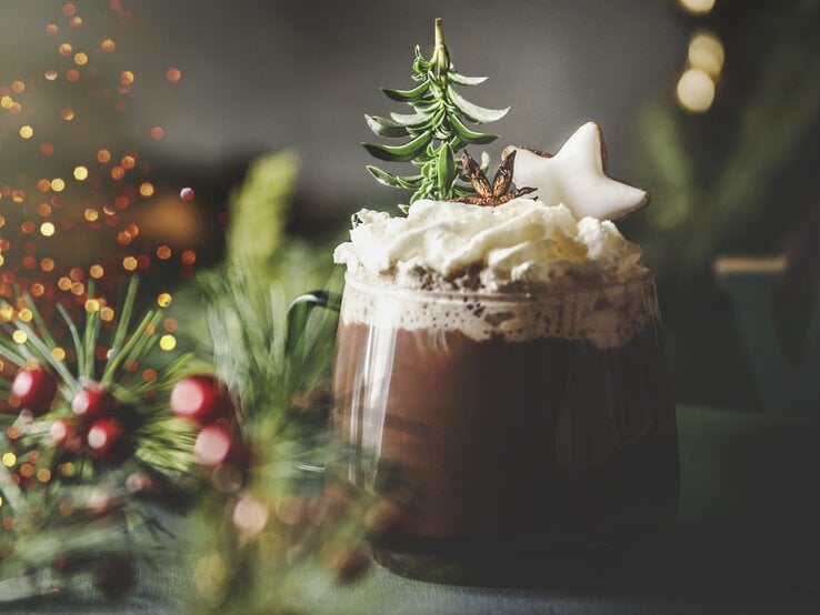 Weihnachtlich dekorierte heiße Schokolade in durchsichtigem Glas. 