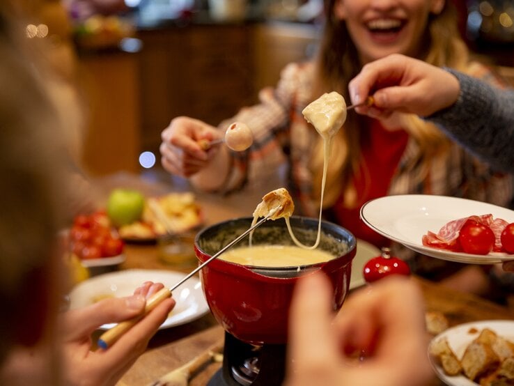 Menschen essen Käse-Fondue. 