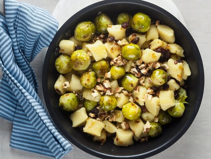 Rosenkohl-Gnocchi-Pfanne mit Walnüssen auf hellem Untergrund. 