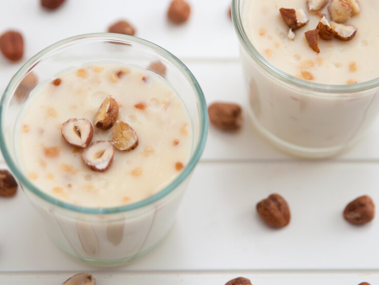 Zwei Gläser mit der Lebkuchen-Mousse und den gehackten Haselnüssen on top.