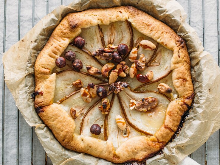 Eine Galette auf Backpapier und einem Metallgitter und weißen Marmortisch.