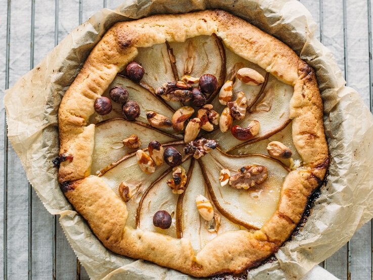 Eine Galette auf Backpapier und einem Metallgitter und weißen Marmortisch.