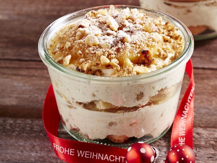 Lebkuchen-Dessert im Glas mit weihnachtlicher Deko auf Holz. 