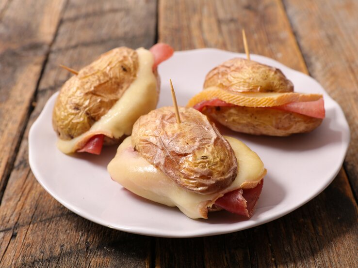 Mini-Burger aus Kartoffel belegt mit Schinken und Raclette-Käse. 