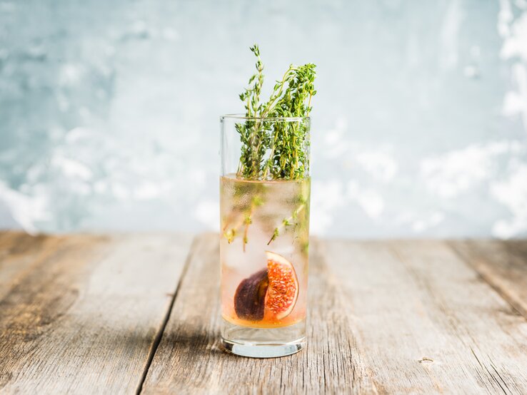 Ein Glas Feigen-Fizz mit Thymian und frischen Feigen.