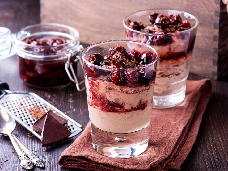 Zwei Gläser gefüllt mit einem weihnachtlichen Dessert: Glühweinkirschen in einer zimtigen Mascarpone-Creme. 