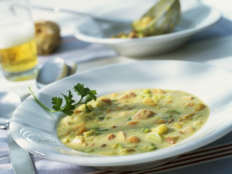 altmodischer Teller gefüllt mit >Erbsensuppe und Würstchen. 