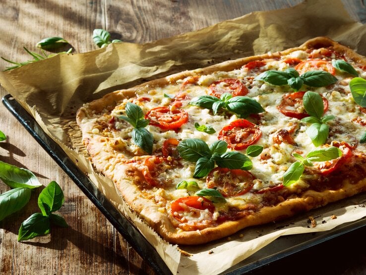 Ein Pizzablech belegt mit Pizza. | © iStock/Vima