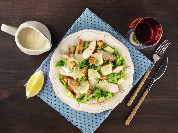 Draufsicht auf einen teller mit Salat, garniert mit hausgemachtem Caesar Dressing.