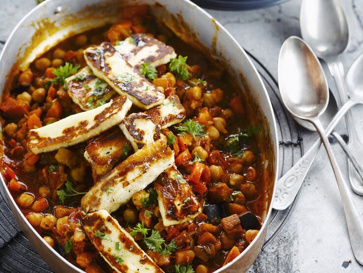 Auflaufform gefüllt mit einem Kichererbsen-Gulasch mit Halloumi.