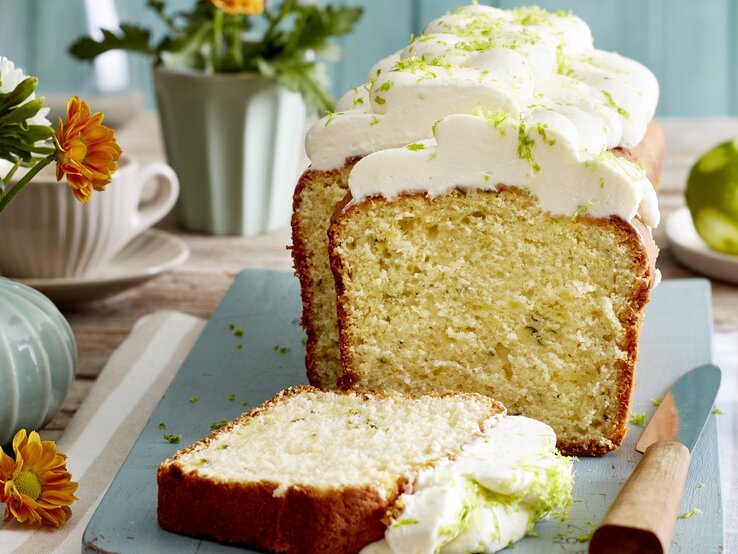 Angeschnittener Limetten-Zucchini-Kuchen auf einem blauen Teller. 