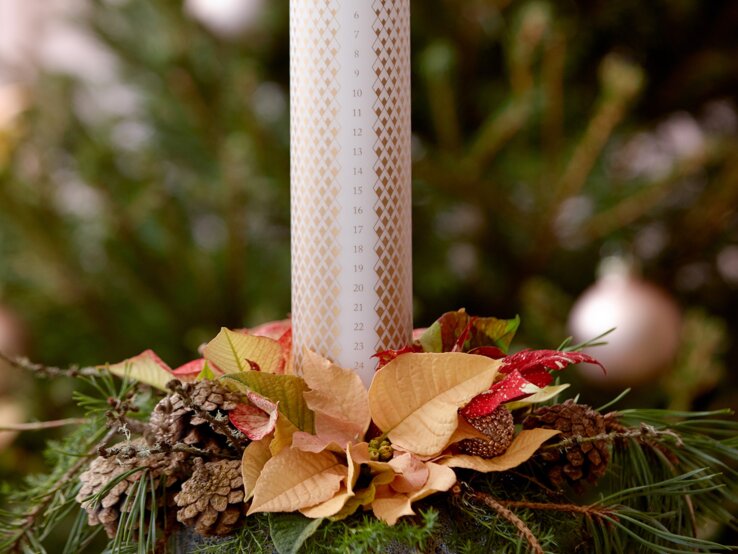 Adventsskerze mit Weihnachtsstern-Gesteck | © starsuniteeurope.eu