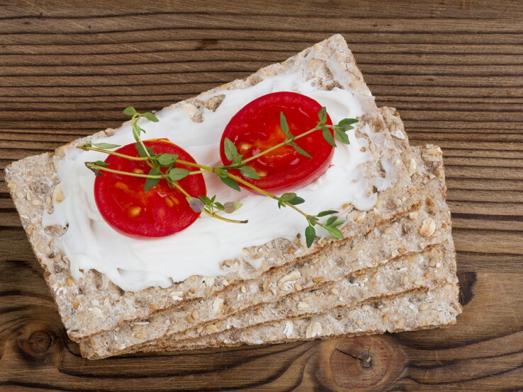 1 Scheibe Knäckebrot (12 g) mit 1 Tomate (50 g) und 1 EL Frischkäse (30 % Fett) hat 75 kcal. | © iStock/beyhan yazar