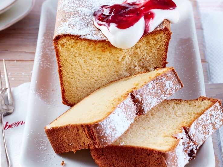 Marzipan-Kuchen mit Schlagsahne und roter Grütze.