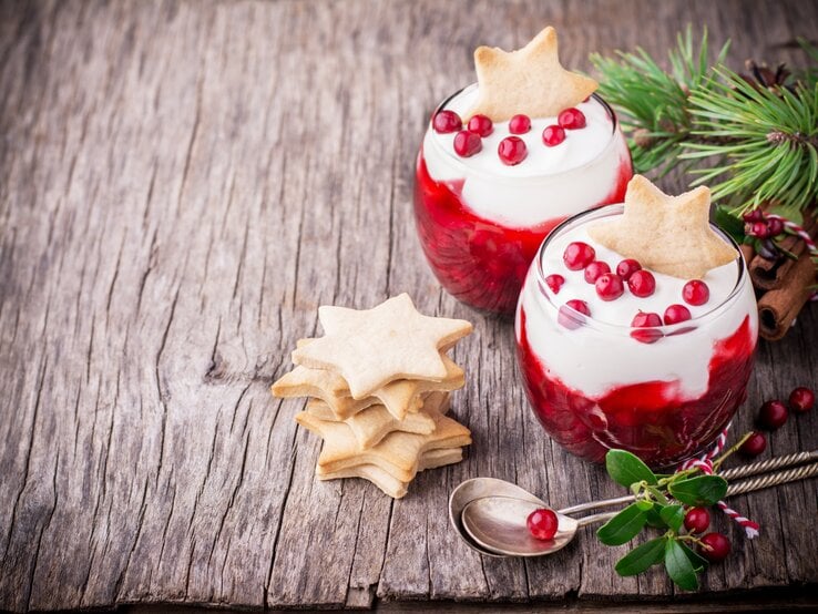 Weihnachtlich dekoriertes Dessert im Glas auf Holztisch. 