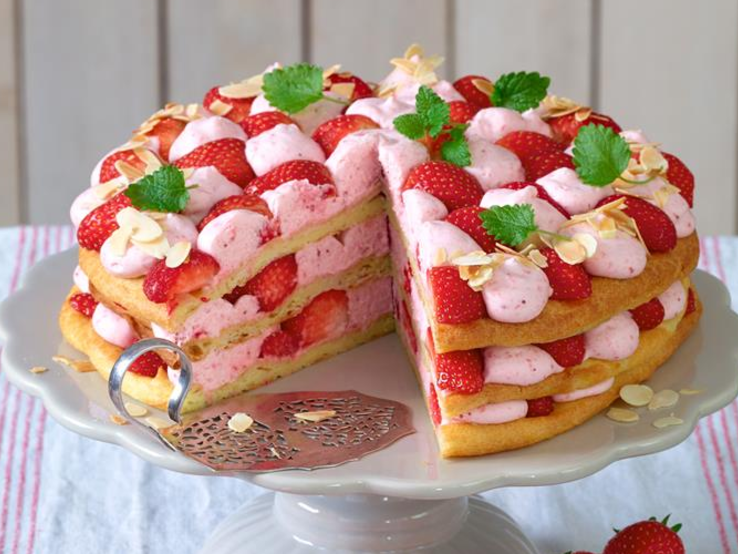 Windbeutel-Torte mit Erdbeer-Sahne auf einem weißen Tortenteller.