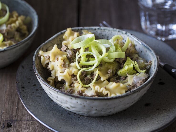 Draufsicht, schräg: eine Schüssel mit einer Hackfleisch-Lauch-Pfanne mit Pasta.