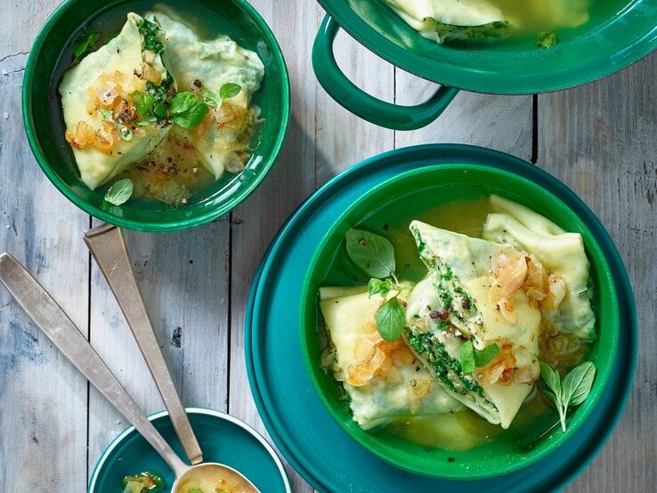 Grünkohl Maultaschen in grünen Schüsselchen auf grauem Hintergrund. 