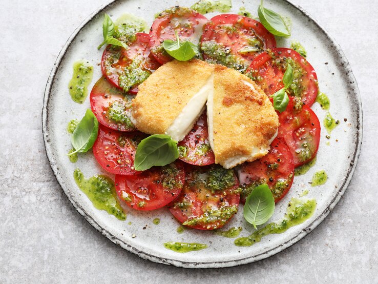 Draufsicht auf einen Teller mit Tomatenscheiben und gebackenem Mozzarella.