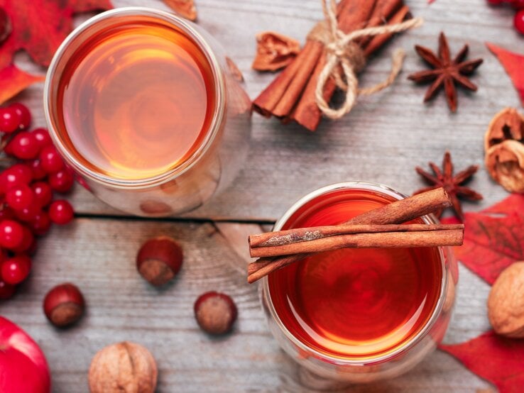 Rosé-Glühwein von oben, umrundet von weihnachtlichen Gewürzen und roter Deko. 