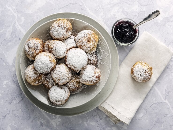 Runde Pfannkuchen mit Puderzucker auf weißem Untergrund. 