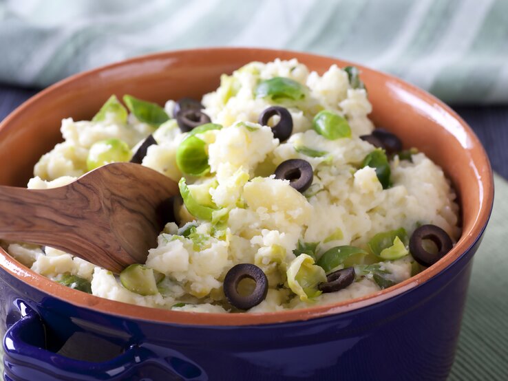 Tonschale gefüllt mit Kartoffelpüree mit Oliven und Rosenkohl.