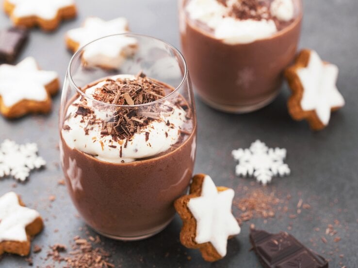 Weihnachtliche Schokoladen-Mousse im Glas, angerichtet mit Sahnecreme, Schokoraspel und Zimtsternen.