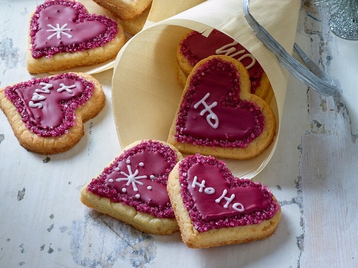 Herzige Weihnachtsplätzchen in einer Papiertüte auf hellgrauem HIntergrund.