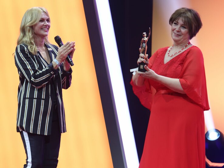 Anna Loos überreicht Andrea Krull eine GOLD-Figurine. | © BILD der FRAU