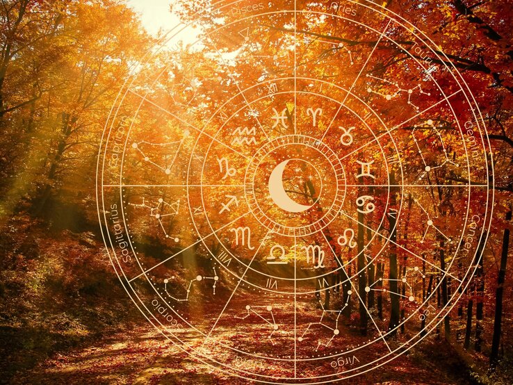 Ein herbstlicher Wald mit leuchtenden, orangefarbenen Blättern wird von Sonnenstrahlen durchflutet. Über die Szenerie ist ein großes astrologisches Rad mit Tierkreiszeichen und einem zentralen Mondsymbol projiziert. Die Kombination aus Astrologie und der Herbstlandschaft symbolisiert die Herbst-Tagundnachtgleiche und den Übergang in die Waage-Saison, die Harmonie, Gleichgewicht und Veränderung im Jahreszyklus repräsentiert.