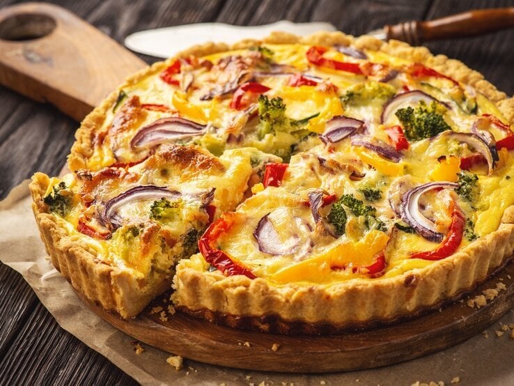 Vegetarische Quiche mit Brokkoli und Paprika auf einem Holzbrett. | © iStock.com/iko636