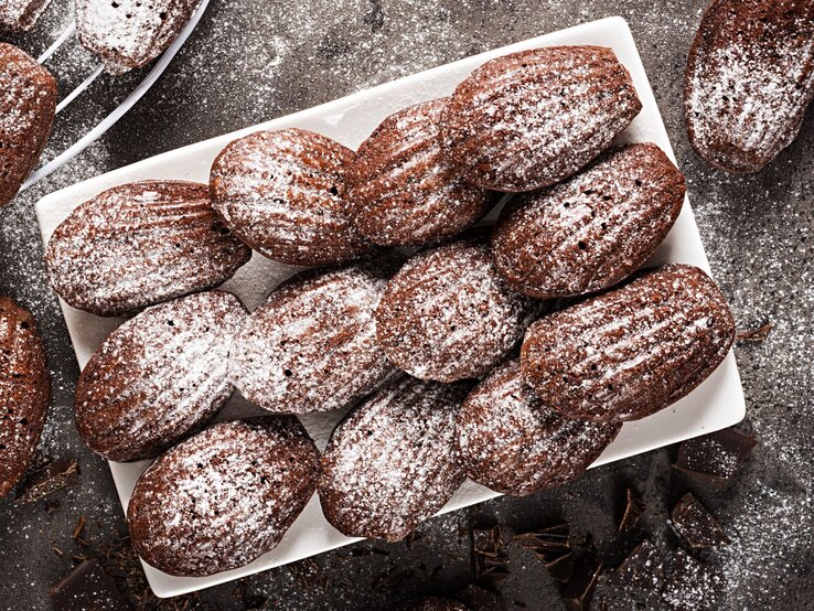 Mit Puderzucker bestäubte Bärentatzen-Plätzchen auf weißem Teller.  | © Shutterstock/Timolina