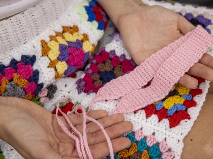 Ein gehäkeltes DIY-Haarband in rosa wird in den Händen gehalten. | © Georg Lukas