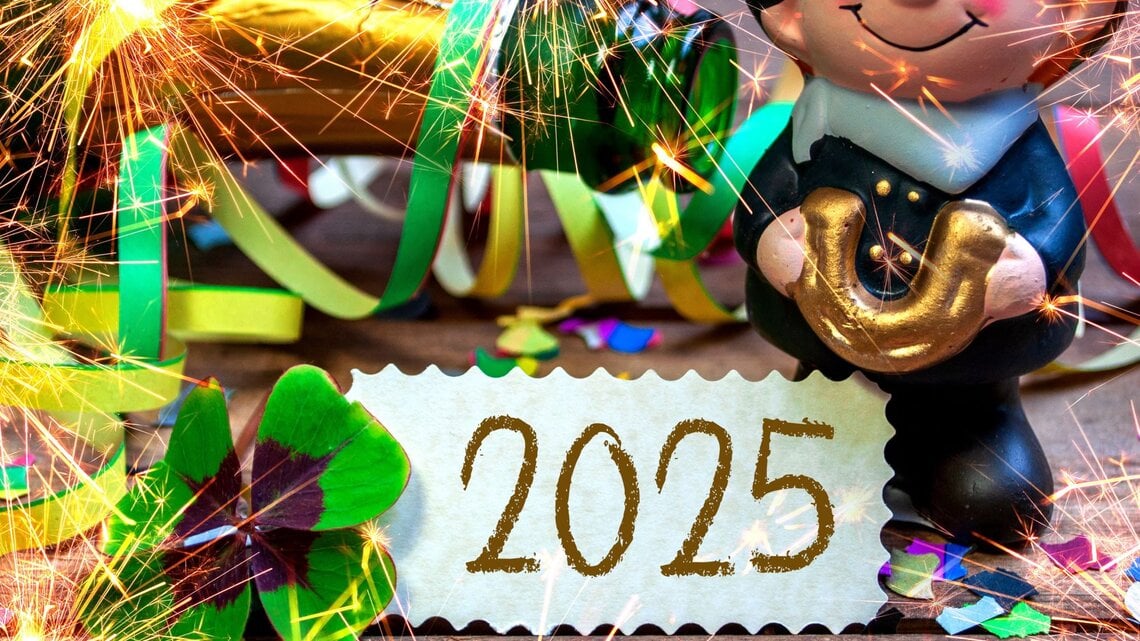 Glücksbringer-Figur mit goldenem Hufeisen, Kleeblatt, bunten Luftschlangen und Wunderkerzen vor einer Karte mit „2025“.