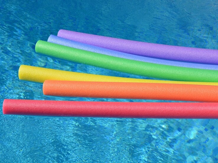 Bunte Schwimmnudeln im Wasser. 