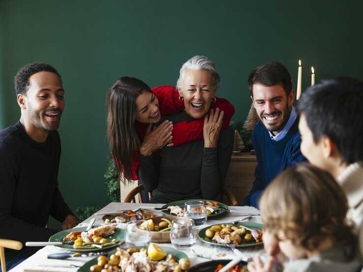 Zu sehen ist eine glückliche Familie an Weihnachten