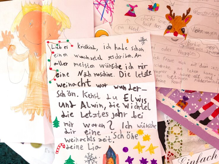 Kinderzeichnungen und Wunschlisten mit fröhlichen Farben und handgeschriebenen Botschaften, im Fokus ein Brief mit weihnachtlichen Verzierungen. | © BILD der FRAU 