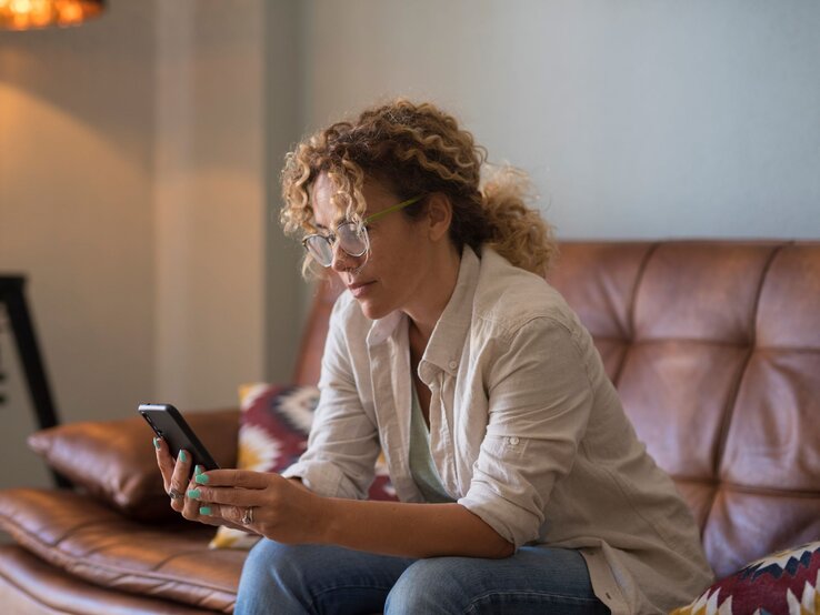 Frau auf Sofa mit Handy