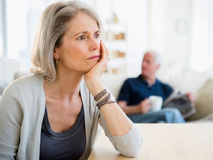 Nachdenkliche Frau und Mann mit Zeitung 