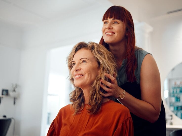 Zu sehen ist eine Frau mittleren Alters, die eine neue Frisur bekommt.