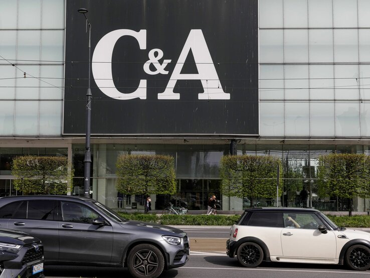 C&A-Gebäude mit großem Logo, davor fahren Autos auf der Straße