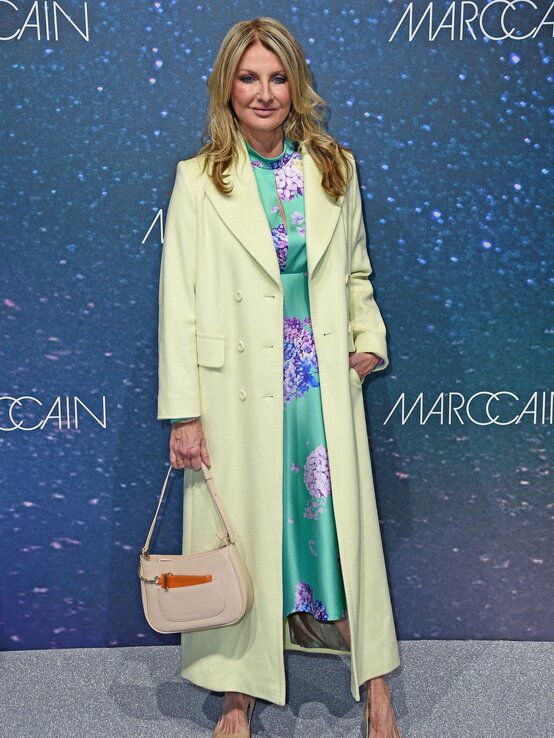 Elegant gekleidete Frauke Ludowig mit welligem, blondem Haar trägt ein mintgrünes Kleid mit floralem Muster, hellgrünen Mantel und nudefarbene Pumps. | © Tristar Media/WireImage)